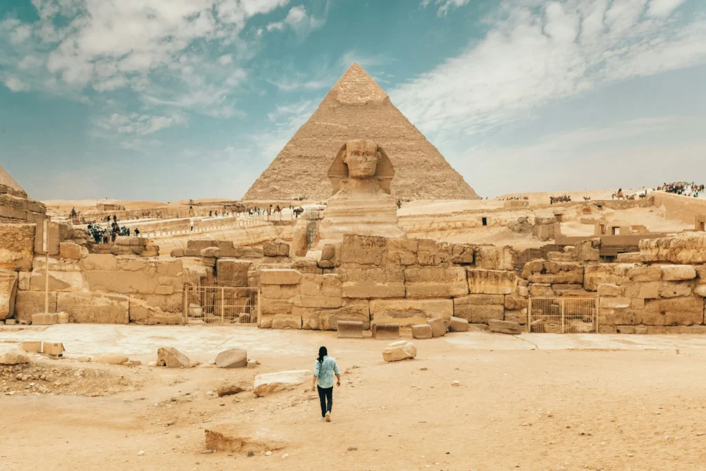 Person facing the Pyramids of Giza and the Great Sphinx.