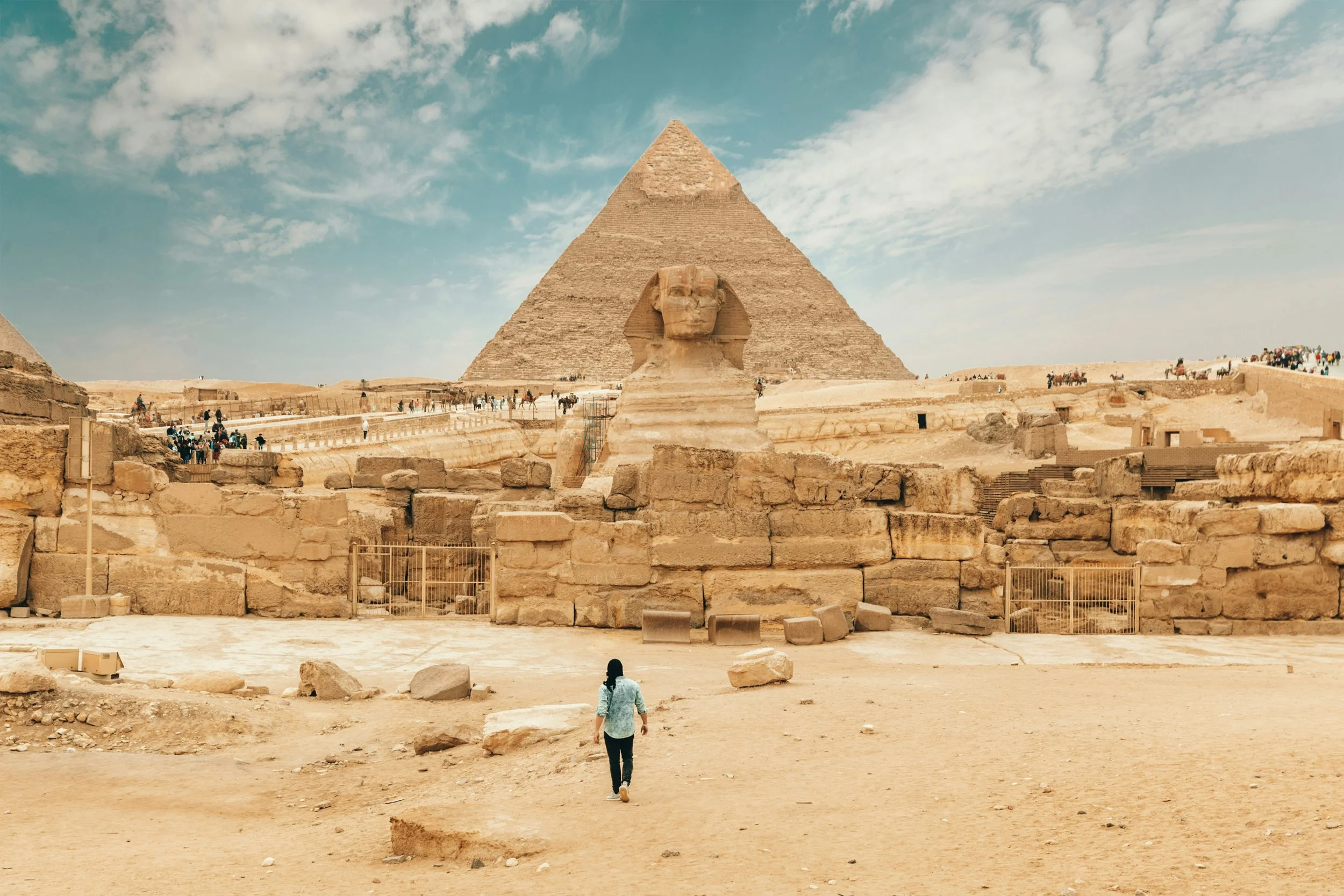 Person facing the Pyramids of Giza and the Great Sphinx.